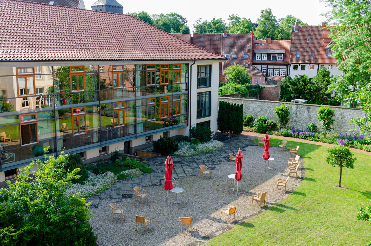 LÜCHTENHOF - Überblick über den Hofgarten, der sich in den Fenstern des Neubaus spiegelt