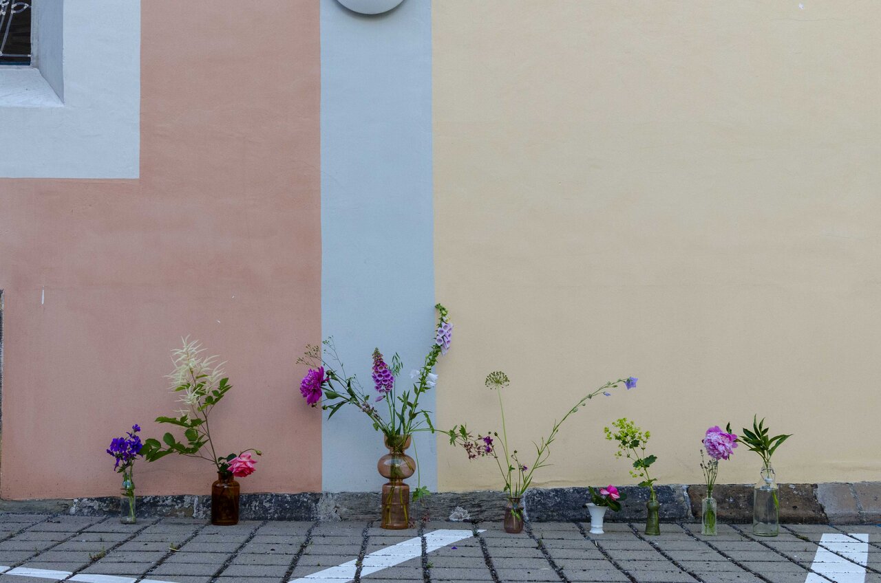 LÜCHTENHOF - Eingangsbereich mit vielen unterschiedlichen Blumen in verschiedenen Vasen