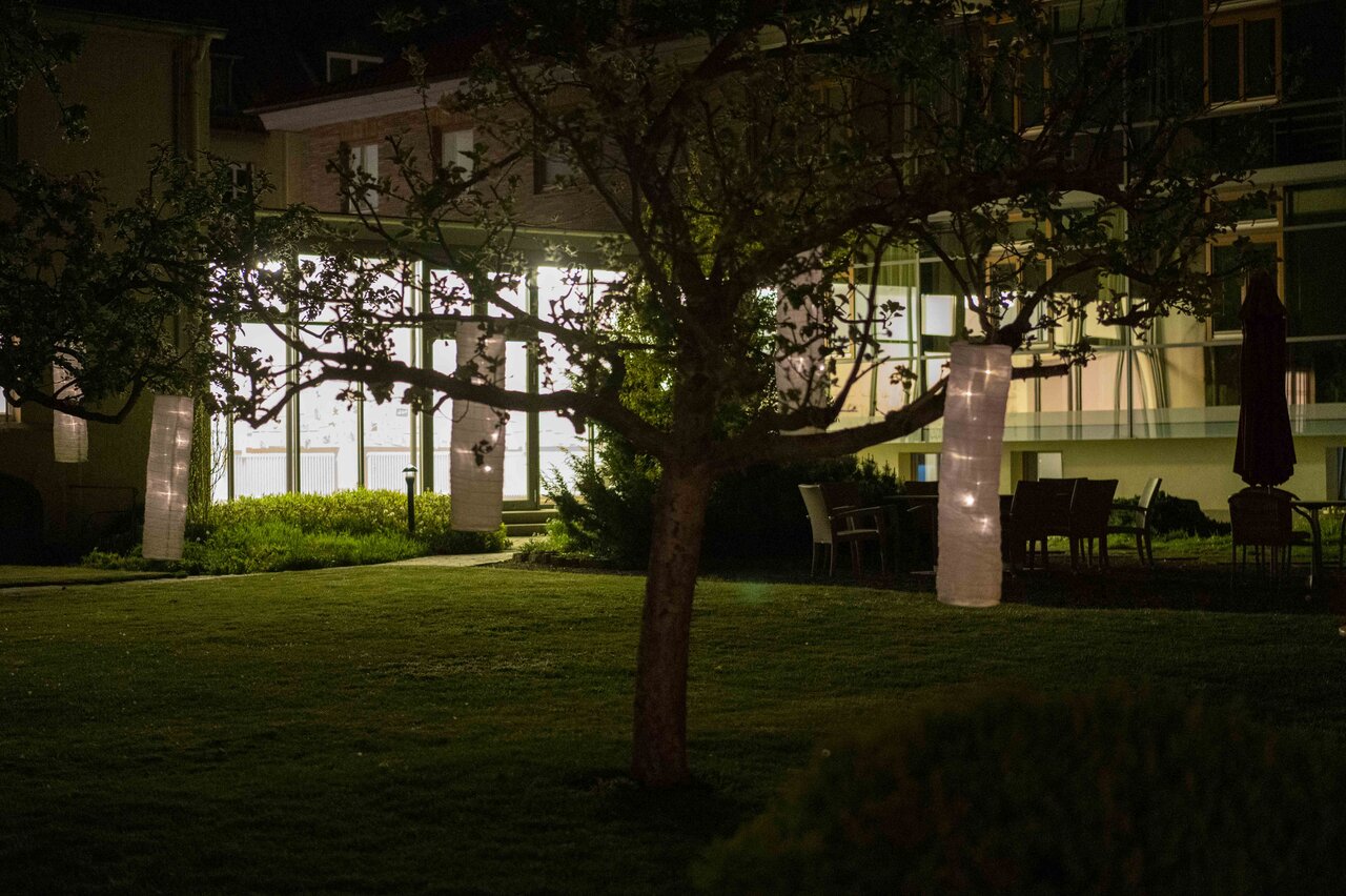 LÜCHTENHOF - Abendstimmung im Hofgarten mit leuchtenden Lampions in den Bäumen