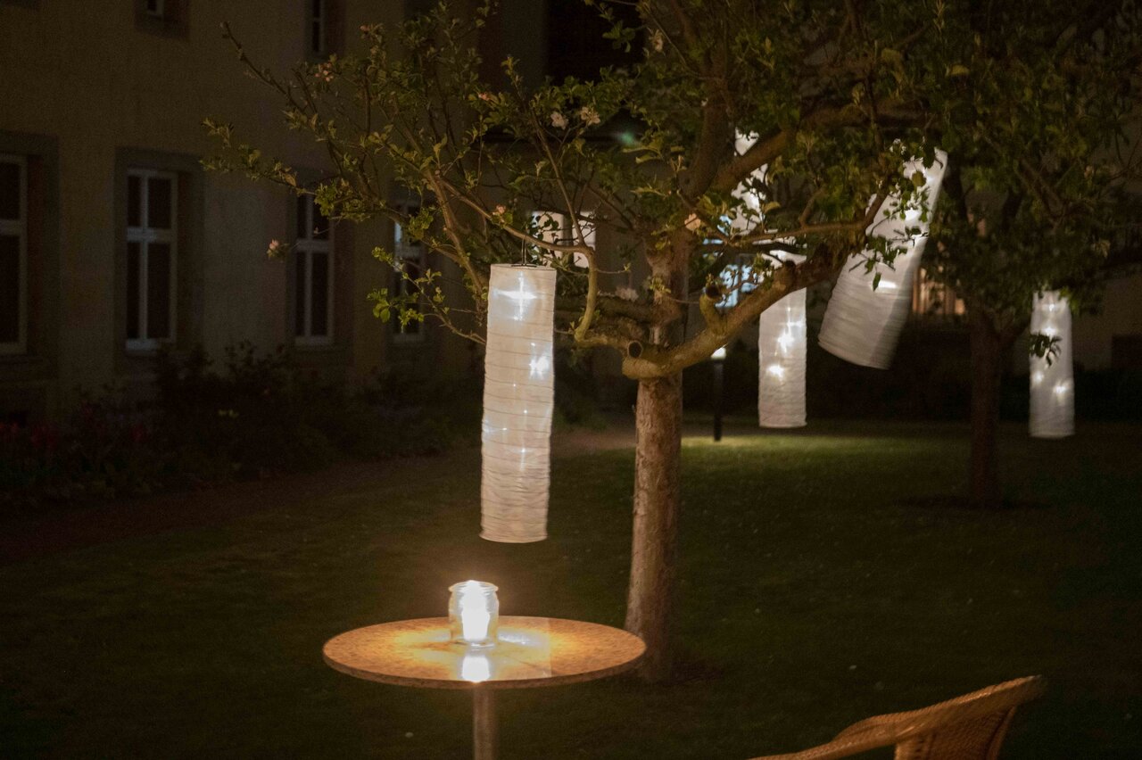 LÜCHTENHOF - Abendstimmung im Hofgarten mit leuchtenden Lampions in den Bäumen