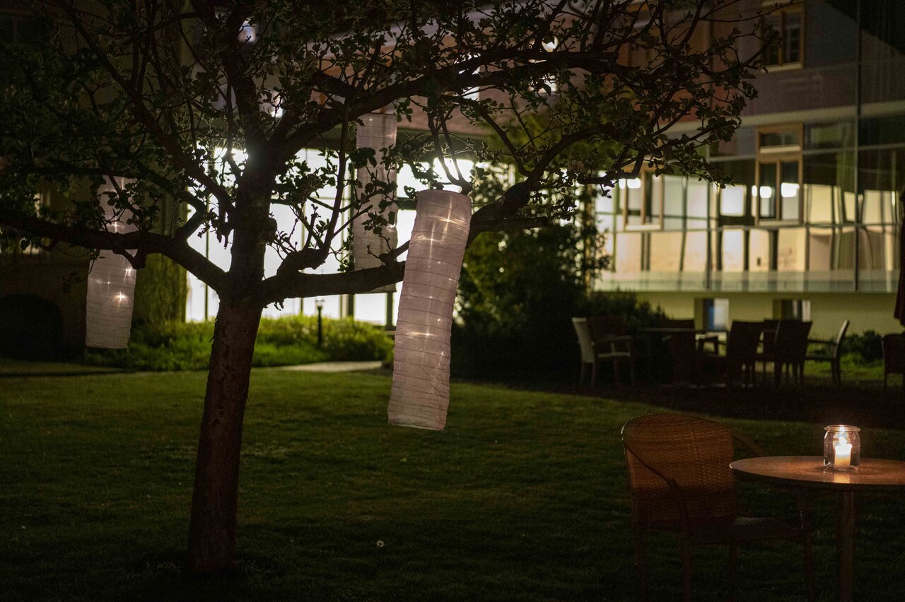 LÜCHTENHOF - Abendstimmung im Hofgarten mit leuchtenden Lampions in den Bäumen